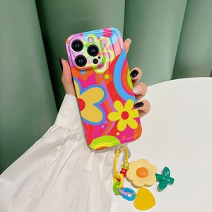 Detail view of iPhone Pro case with retro floral patterns and colorful charm chain strap