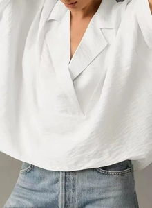 Detail of white satin short sleeve shirt showing the silky texture and classic V-neck collar