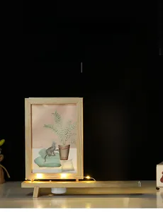 Détail d'un cadre photo en bois rotatif avec arbre LED et figurine de chien mignonne