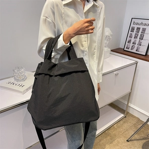 Women's black casual nylon tote bag shown by a model for a minimalist lifestyle look