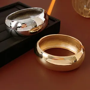 Polished dome open bangle bracelets in gold and silver finish with a minimalist thick design