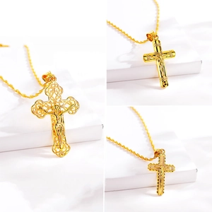 Three gold Jesus cross necklaces with intricate filigree and polished metal details