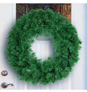 Lush green artificial PVC Christmas wreath hanging on a classic white front door