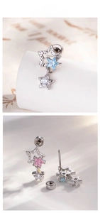 Detail of star-shaped cartilage stud earrings with zircons and hammered metal finish