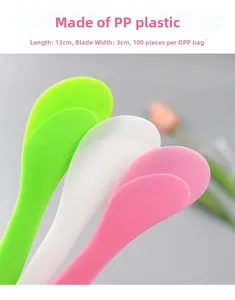 Close-up of 13cm plastic face mask spatulas in green, white, and pink for skincare mixing