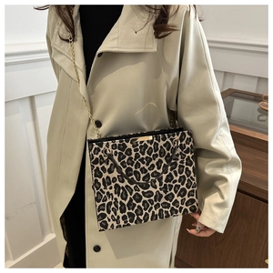 Détail du sac cabas léopard avec poignées noires et bandoulière chaîne dorée porté