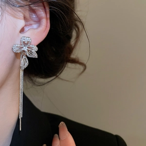 Detail of silver tassel flower earrings with cubic zirconia on a female model