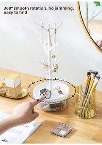Rotating jewelry organizer with tree-shaped branches and tiered tray on a vanity desk
