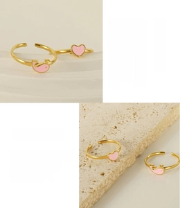 Detail of 18K gold plated heart and dolphin enamel rings with adjustable bands
