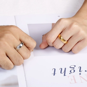 Minimale zweifarbige Paar-Ringe aus Gold und Silberstahl auf einem Magazin-Hintergrund