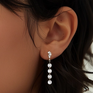Macro shot of S925 silver long tassel earrings with sparkling teardrop crystals on model