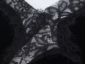 Detail aus elegantem schwarzem Spitzenstoff mit Wimpernborte und Blumenstruktur