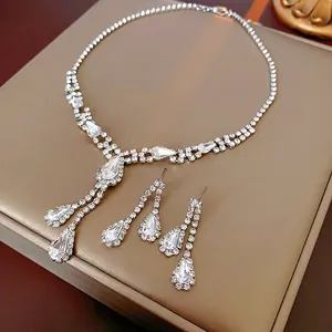 Elegant silver-tone water drop rhinestone necklace and earring set on a leather jewelry box