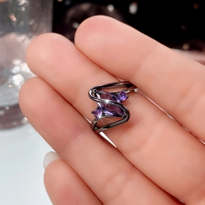 Close-up of gunmetal plated ring with marquise-cut purple zircon in a streamlined design