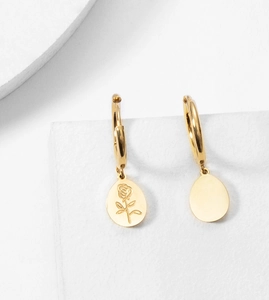 Detail of gold hoop earrings featuring engraved rose motif and plain round pendants