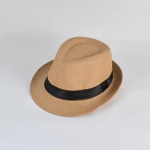 Detailed close-up of woven paper straw texture and black ribbon on a summer fedora hat