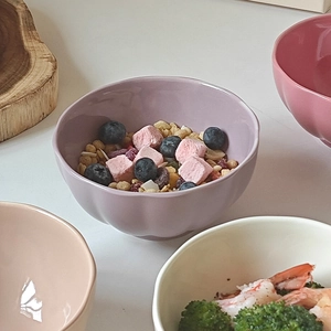 Detail view of a lavender petal-shaped ceramic bowl filled with cereal and blueberries