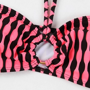 Détail du maillot de bain rayé rose et noir en seersucker avec un anneau doré central