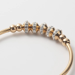 Detailed macro shot of a gold titanium steel bracelet with sparkling zircon beads