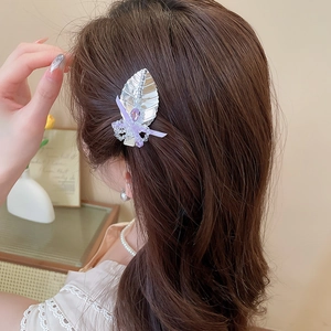 Détail d'une pince à cheveux feuille argentée avec cristal violet et nœud en mesh