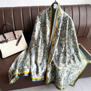 Écharpe en satin de soie bleu clair à motif cachemire sur un canapé en cuir