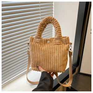 Detail shot of khaki corduroy bucket bag with soft texture and magnetic button closure