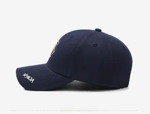 Détail de casquette bleu marine avec broderie NY&JA et motif de petit ours brodé