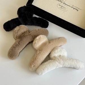 Detailed view of four soft plush hair claws in black, brown, beige and white colors