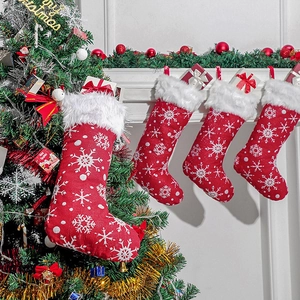Set of 4 red Christmas stockings with white snowflake embroidery hanging by the fireplace
