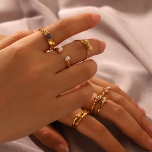 Detail of 18K gold bow and pearl ring set with purple zircon stones on soft silk background