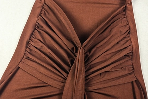 Detail of coffee brown pleated fabric showing silky texture and ruched design of the dress