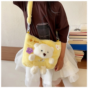 Detail of yellow plush kids crossbody bag featuring 3D teddy bear and floral accents