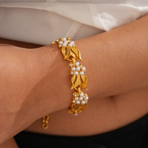 Close-up of golden leaf bracelet with pearls and rhinestones on woman's wrist