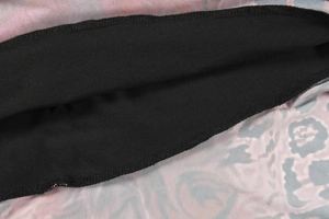 Détail du tissu en maille léopard rose avec doublure noire et coutures soignées