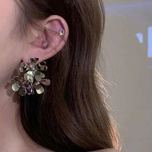 Close-up of a silver layered floral metal earring worn on a model for a chic vintage look