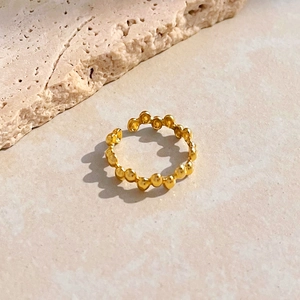 Detailed view of gold-plated beaded bubble ring on a minimalist marble background