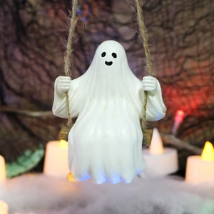 Detail of a white resin ghost sitting on a wooden swing with hemp rope and a candlelit background