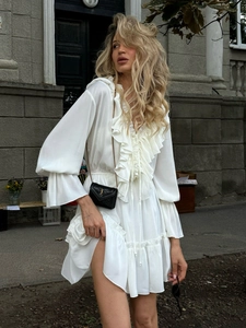 Detail of white chiffon dress with deep V-neck, layered ruffles and elegant lantern sleeves