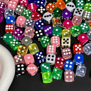 Close-up of colorful resin dice pendants with silver metal loops for DIY jewelry making