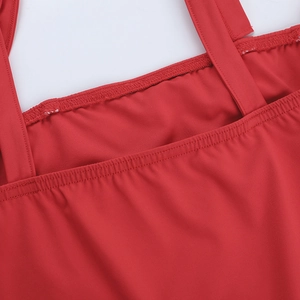 Détail de l'encolure de la robe rouge et des fines bretelles avec coutures renforcées
