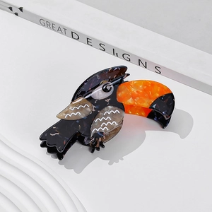 Chic acetate toucan hair claw clip with colorful marble pattern on white display