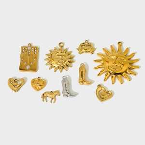 Detailed flat lay of gold stainless steel charms featuring sun, moon, and cowboy boot designs