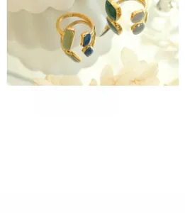 Detail view of gold adjustable rings with blue and green geometric gemstone inlays