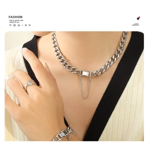 Detail of silver stainless steel thick Cuban chain necklace and bracelet set on model