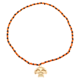 Primer plano de collar de cuentas de Halloween con colgante de calavera dorada y cascos
