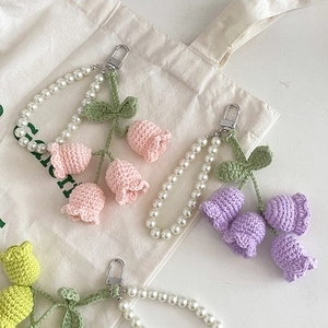 Handmade crochet lily of the valley keychains with pearls and metallic clasps in pastel colors