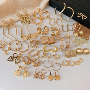 Flat lay of diverse gold geometric earrings including hoops and textured designs