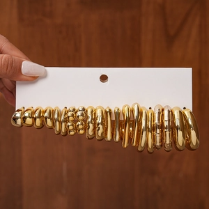 Detailed view of 20-piece gold geometric stud earring set on display card