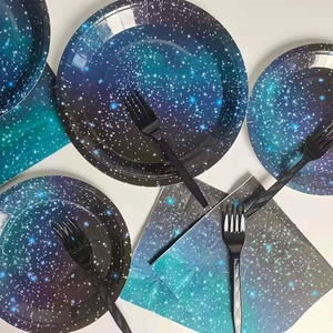 Close-up of starry sky themed disposable plates, napkins and black forks for space party