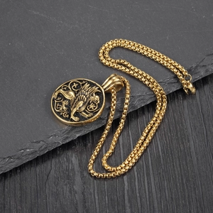 Makroaufnahme eines goldenen Greif-Reliefanhängers auf einer runden schwarzen Medaille